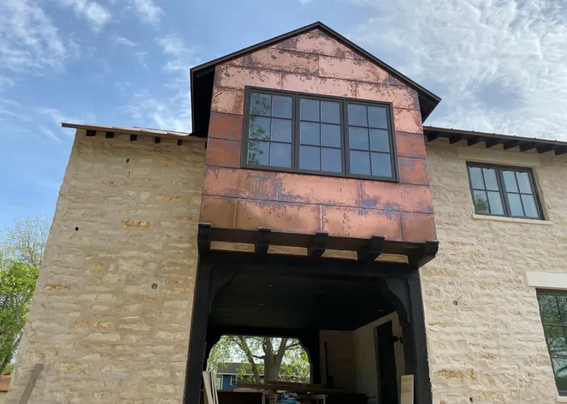 Copper metal panel facade on a stone building for Roof Repair in Yankee Springs