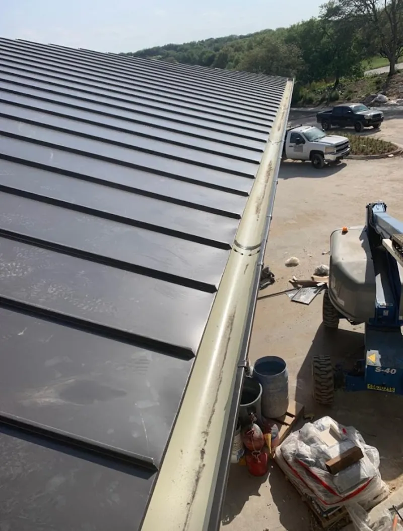 Standing seam panel and gutter detail on a metal roofing jobsite in Yankee Springs